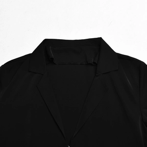 Close-up of a black suit jacket featuring a classic V-shaped lapel and smooth fabric