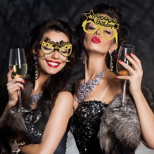 Women in party dresses wearing black and gold 40th birthday glitter paper glasses