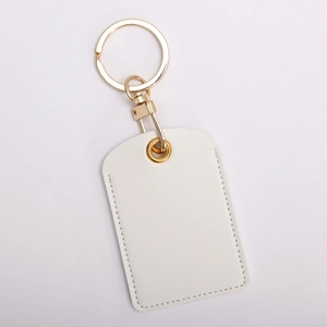 Close-up of white leather access card holder keychain with gold hardware and fine stitching