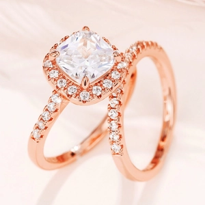 Macro shot of rose gold cushion-cut halo engagement ring set with micro-pave diamond band