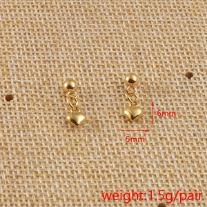 Détail de boucles d'oreilles cœur doré montrant les dimensions 6mm par 5mm