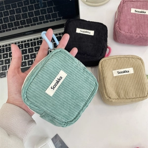 Detail of corduroy cosmetic pouches in mint, black, pink, and beige with zippers