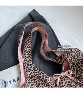 Close-up of leopard print shoulder bag with pink satin lining and bow detail