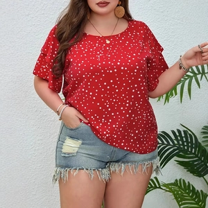 Detail of red polka dot top with ruffle sleeves paired with distressed denim shorts