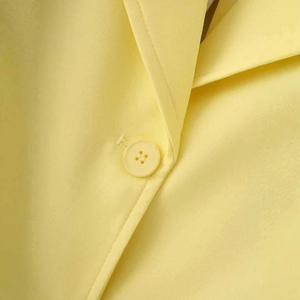 Front detail of bright yellow satin blazer with fine twill texture and matching buttons