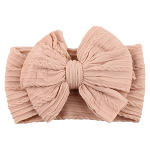 Detail of baby nylon headband featuring a large dusty pink cable knit bow