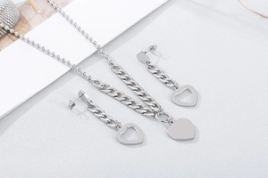 Detailed view of silver stainless steel heart necklace and matching earrings set