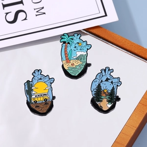 Creative anatomical heart enamel pins with desert, beach, and forest scenery illustrations