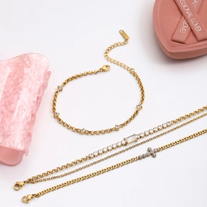 Detailed view of 18K gold stainless steel bracelets with cross pendant and zircons