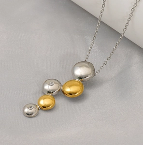 Détail du collier bicolore en acier inoxydable avec pendentif grappe et oxydes de zirconium