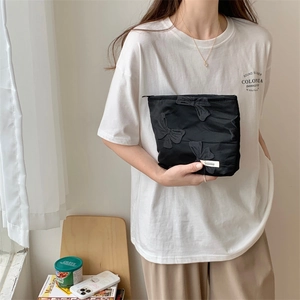 Detailed close-up of a black canvas makeup bag with 3D butterfly embroidery and zipper