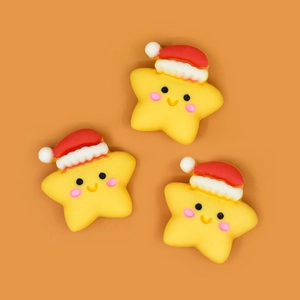Close-up of three yellow star resin charms with Christmas hats for DIY hair accessories