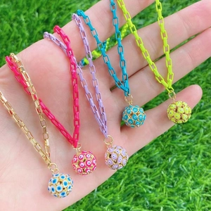 Bunte Halsketten mit blauen Evil-Eye-Anhängern auf Gras im Freien präsentiert