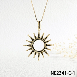 Macro view of gold sun pendant necklace featuring pave set black cubic zirconia stones