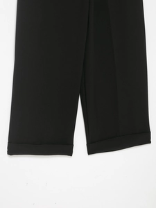Close-up detail of fixed folded cuffs and premium stitching on black casual trousers