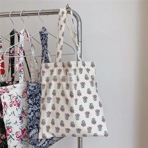 Detail of floral canvas tote bags with various vintage patterns and woven fabric labels