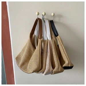Detailed view of woven mesh bags with leather straps in brown, white, and black colors