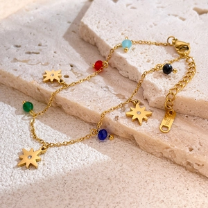 Detailed close-up of golden stainless steel star bracelet with multicolored beads