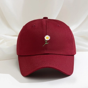 Dettaglio della margherita ricamata su un cappello di cotone bordeaux con visiera curva