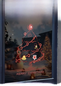 Close-up of a festive Christmas tree window sticker with Merry Christmas greeting