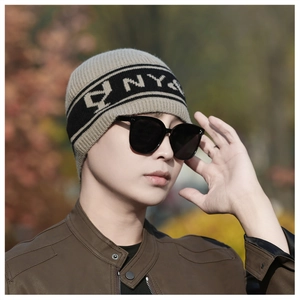 Photo lifestyle d'un bonnet en maille rayé gris et noir avec inscription NY