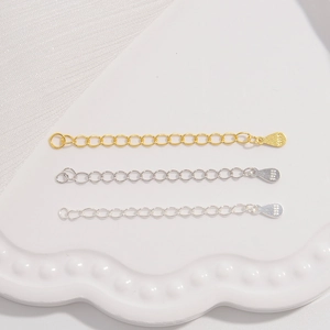 Macro detail of S925 sterling silver heart and drop extension chains in gold and silver