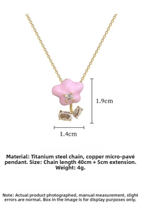 Detailed shot of pink enamel flower pendant with zircon inlay on gold titanium chain
