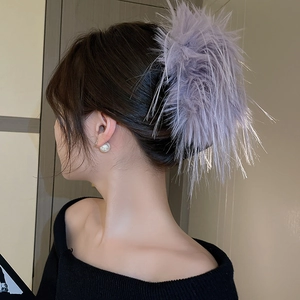 Detail of light purple feather hair claw clip on model hair with white pearl earring