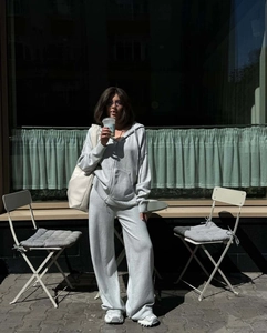 Dettaglio felpa con cappuccio grigia e pantaloni a gamba larga in stile street chic