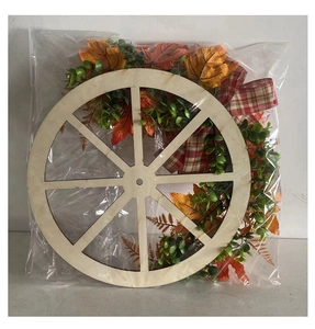 Detail of autumn harvest wreath featuring a rustic wooden wheel with orange maple leaves