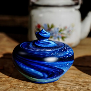 Detailed view of artistic blue galaxy texture glass jar with pointed lid for home storage