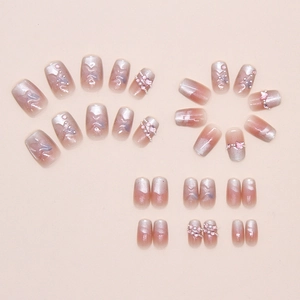 Close-up of cat-eye gradient press-on nails with 3D pink bows and pearl accents