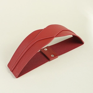 Detailed close-up of red PU leather waist belt with geometric stitching and button closure