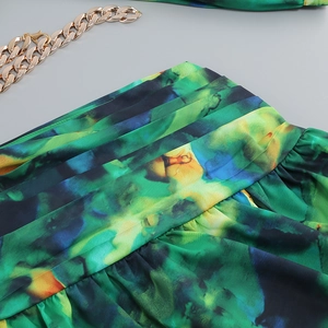 Close-up of abstract floral print fabric with ruched waist and vibrant color watercolor patterns