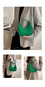 Macro view of green crocodile pattern crescent bag with premium gold hardware