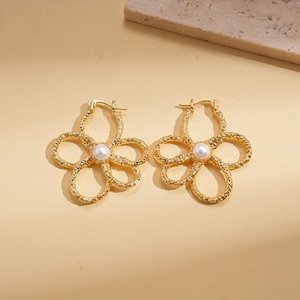 Detail of 18K gold plated flower earrings with textured petals and center pearl
