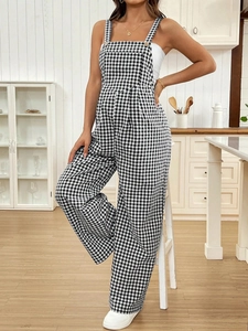 Detail of checkered maternity overalls with button straps in a cozy kitchen setting