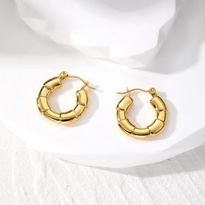 Detailed view of golden bamboo textured hoop earrings with a secure hinge clasp