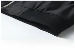 Close-up of black flight jacket hem showing ribbed knit cuffs and silver metal zipper detail