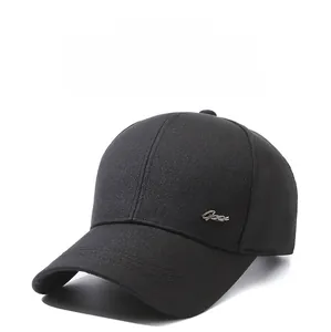 Dettaglio di un cappellino da baseball nero con logo in metallo argento e cuciture rifinite