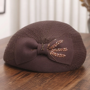 Detail of dark brown wool beret with mesh veil, bow and golden wheat beadwork