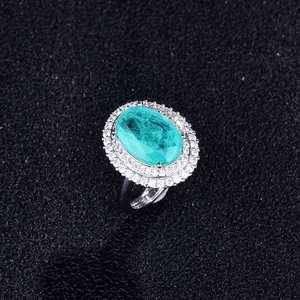 Macro shot of Paraiba colored oval stone with double halo micro-pave diamonds on silver ring