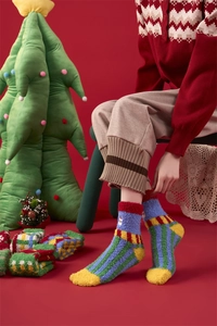 Close-up of fluffy Christmas coral fleece socks with colorful stripes and snowman embroidery