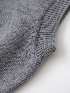 Detailed macro view of the grey knit sweater's ribbed cuffs and high-quality wool fabric texture