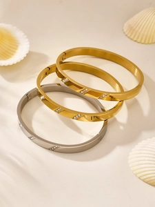 Macro detail of three-piece set stackable bangle bracelets with cubic zirconia and etched patterns