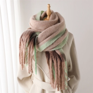 Detail of soft gradient tassel scarf in beige and green on a mannequin with a coat