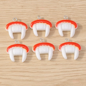 Detailed view of red and white vampire teeth resin charms for DIY jewelry making