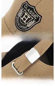 Detail of classic H embroidery and adjustable silver metal buckle on khaki baseball cap