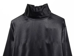 Gros plan sur une chemise en satin noir à col montant avec une texture lisse et brillante