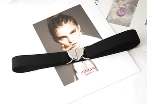 Gros plan d'une ceinture élastique noire avec boucle métallique cœur argentée sur magazine